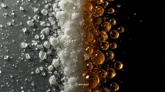 Close-up split composition of white sugar crystals on the left and golden honey droplets on the right against a dark background